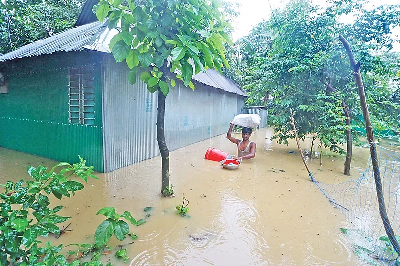 A man tries to save his family belongings from flood water in Chanpur area in Cumilla Sadar upazila on 21 August 2024